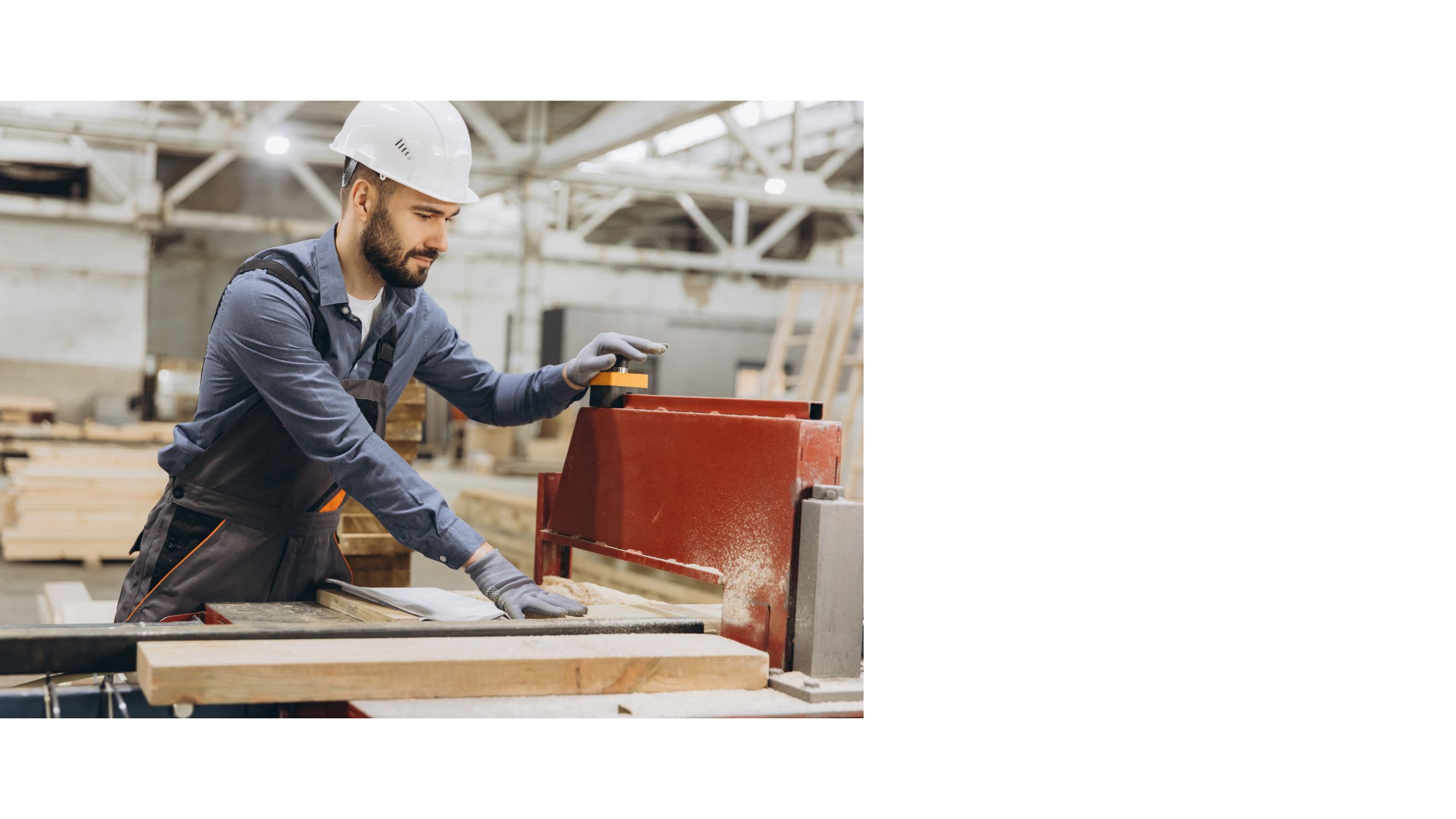 Man in warehouse sawing wood
